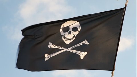 Piratenflagge gegen blauen Himmel. Piraten Flagge im Wind, die den Schädel  und die Kreuzbeine als Symbol der Piraten. Platz für Text Stockfotografie -  Alamy
