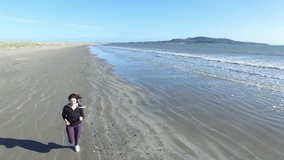 4k Aerial video of a woman exercising on the seaside