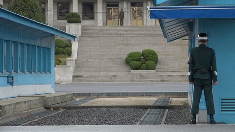 DMZ, SOUTH KOREA - 10 OCTOBER 2015: A South Korean soldier stands guard at the UN buildings at Panmunjom, keeping an eye on their counterparts of the North at the official demarcation line