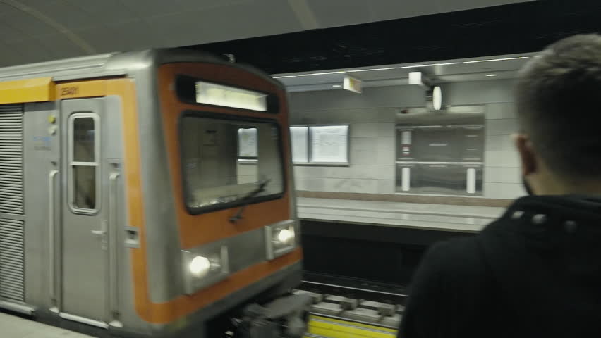 Train arriving at the subway station young man waiting to get in.Handheld clip of a young man first in line waiting for the train to stop so he can get onboard.
