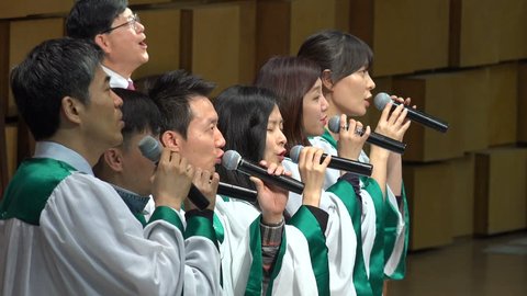 SEOUL, SOUTH KOREA - 11 OCTOBER 2015: Christianity in South Korea, a church choir singing Halleluja, a positive upbeat preacher claps in the background