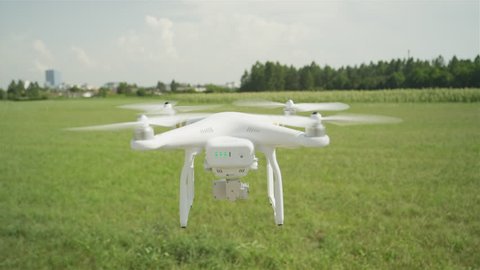 Ljubljana, Slovenia, July 25, 2015, SLOW MOTION CLOSE UP: Small drone flying across the field