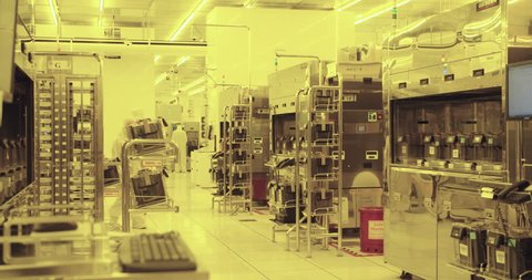 Workers in clean suits in a semiconductor manufacturing facility