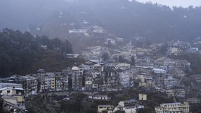 Locked-on shot of houses on hill during rain, Mussoorie, Uttarakhand, India