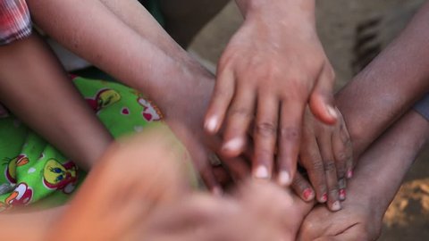 Many connecting children's hands. Mrauk-U, Myanmar