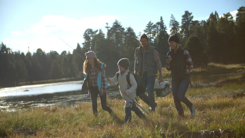 Family arriving back to lakeside tent after fishing Royalty-Free Stock Footage #14757628