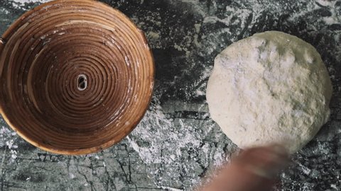 Female working with the dough. Putting the sourdough into the wooden rise basket Stockvideó