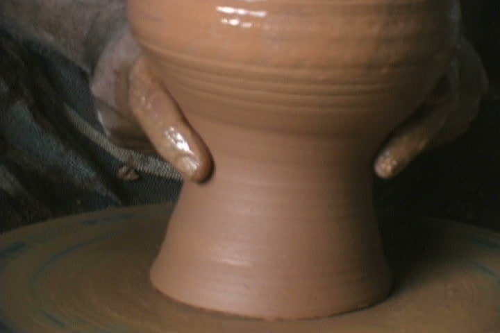 Potter balancing a piece with his finger tips.