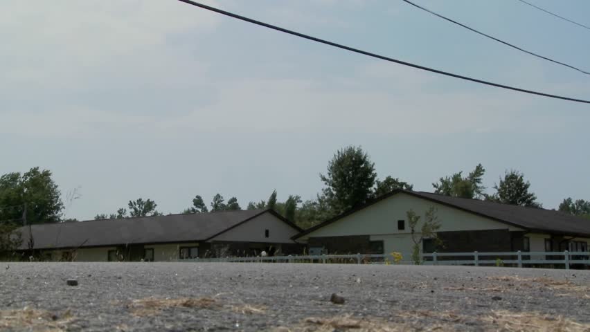 A low angle of an Amish horse and buggy cart moving along a rural road.