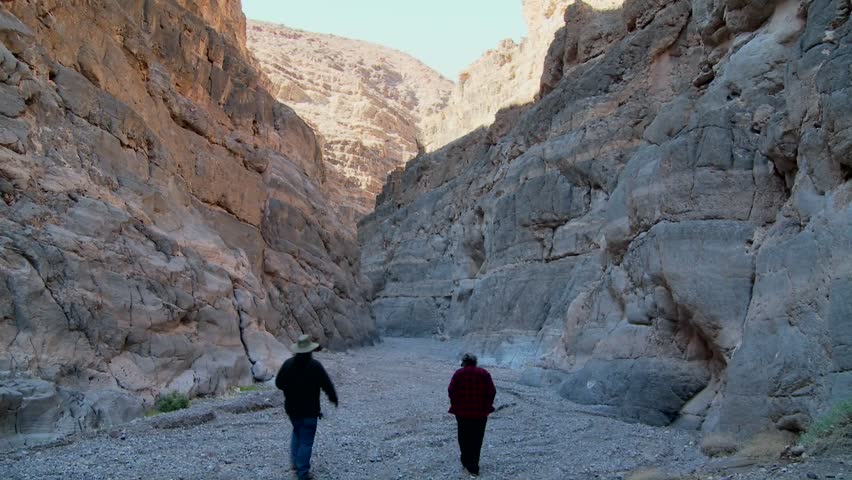 A senior man and woman hike in a canyon in Death Valley.