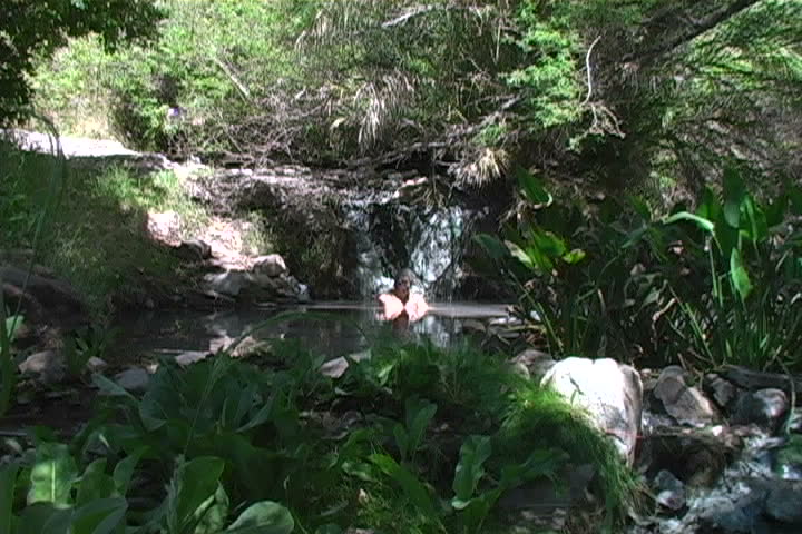 A man bathing in a natural hot-spring.