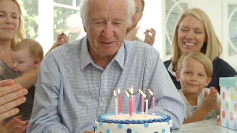 Grandfather Blows Out Candles On Birthday Cake Shot, Slow Motion