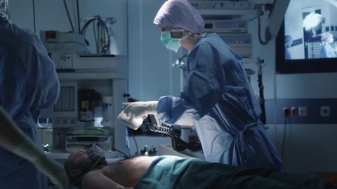 Medical Team Performing Defibrillation in Modern Operating Room. Shot on RED Cinema Camera.