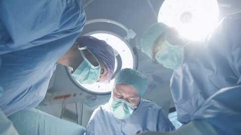 Turning Lights On in Operating Room. Team of Doctors and Nurses over Patient. Patient Point of View. Shot on RED Cinema Camera.