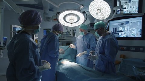Medical Team Performing Surgical Operation in Modern Operating Room. Shot on RED Cinema Camera.