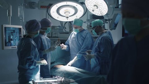 Medical Team Performing Surgical Operation in Modern Operating Room. Shot on RED Cinema Camera.