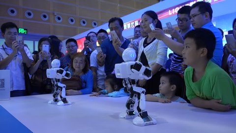 SHENZHEN, CHINA - 20 NOVEMBER 2015: Dancing robots, Gangnam Style (audio stripped), children and their parents, technology trade show, future generation, Shenzhen, China