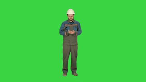 Oil Worker calling by phone during business break on a Green Screen, Chroma Key.