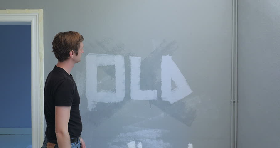 person panting over an old wall with the word old written on it.