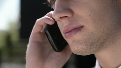 Young businessman talking on the telephone, Close-up of mouth