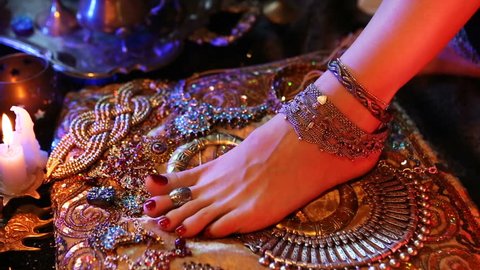 Indian Wedding Preparation. Luxury Oriental Fashion Accessories: Female foot and Hands, Beautiful National Indian Bridal Golden Jewellery. Eastern Traditional Sari clothes. Color lenses, Candlelight.