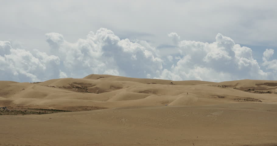 4k timelapse great white puffy cloud mass rolling over desert sand,dunes plateau landform. gh2_08645_4k