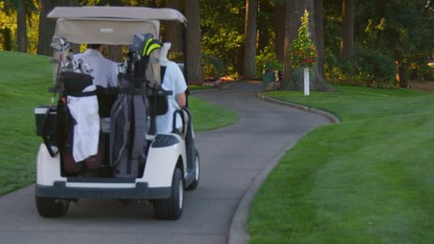 Two golfers ride in a golf cart on a beautiful golf course