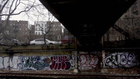 moving subway view of graffiti on urban walls in poverty stricken neighborhood in Brooklyn NYC