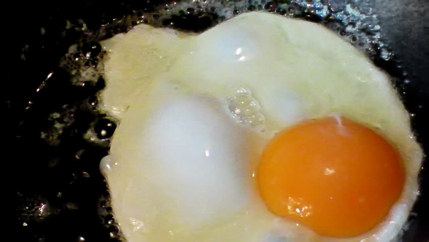 Fried eggs preparation on a frying pan