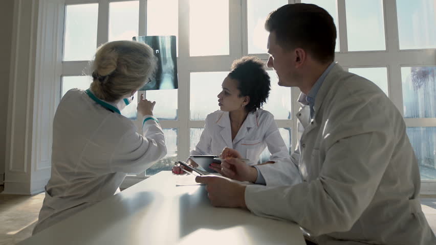 Healthcare, medical: Group of multi-ethnic doctors discuss and looking x-ray in a clinic or hospital