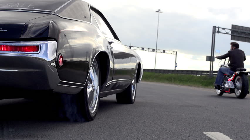 Muscle car slipping on a spot and blowing smoke in slow motion