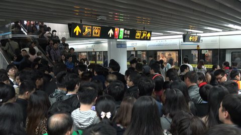 SHANGHAI, CHINA - 5 NOVEMBER 2015: Subway passengers wait to enter the escalators of a crowded metro station, during rush hour in Shanghai, China
