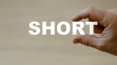 Shot of Hand holding the word SHORT