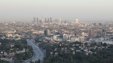 LOS ANGELES, USA - APR 15, 2015: 4k time lapse of sunset view of downtown Los Angeles from the Hollywood Hills with Interstate 101 in the foreground.