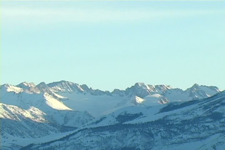 Zoom-out of snow covered mountains in the eastern sierras.