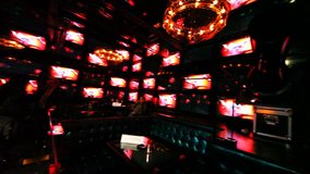 cafe with walls lined of many glowing monitors in checkerboard pattern, panorama left to right
