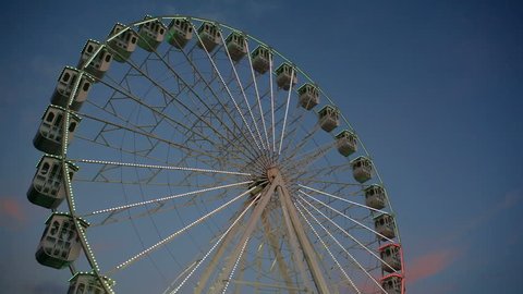 Ferris wheel with lights spins slowly, medium shot, Cascais, Portugal