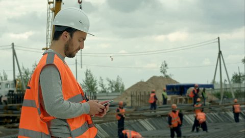 Construction worker talking on the phone at a building site
