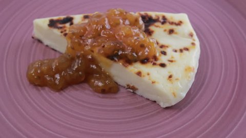 Finnish squeaky cheese with cloudberry jam on a purple plate