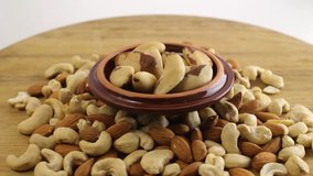 An assortment of nuts on wooden table.  Almond, cashew and brazilian nuts