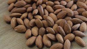 Almonds rotating on wooden table close up
