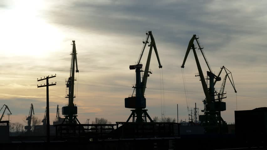Time lapse working cranes in the port at sunset.
