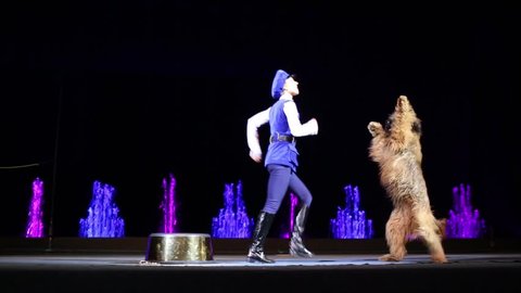 MOSCOW, RUSSIA - DEC 18, 2014: Female animal tamer performs with shagged dog on stage during christmas performance at circus of dancing fountains Akvamarin.