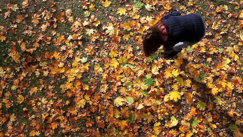 Girl in park throwing leaves