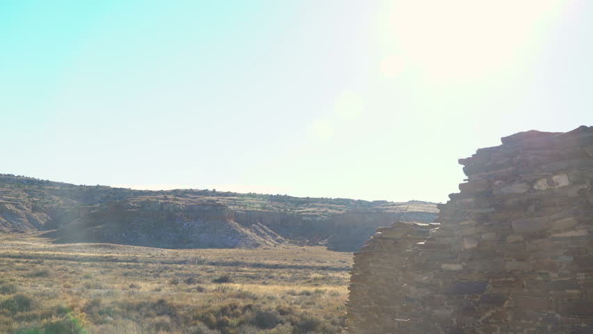 Tracking shot with pan left motion of exterior of Pueblo Bonito ruin at Chaco Culture National Historic Park in New Mexico