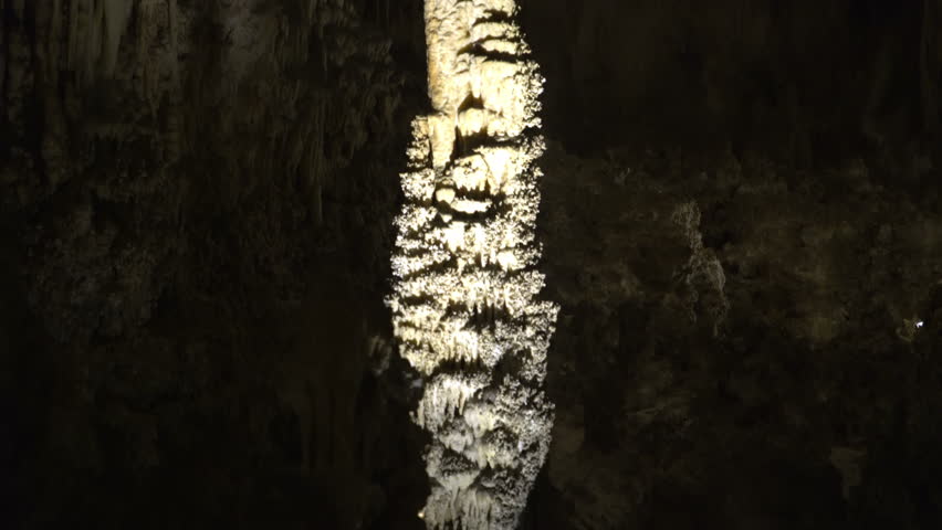 Tracking shot with tilt up motion of a thin stalagmite in Carlsbad Caverns National Park in New Mexico
