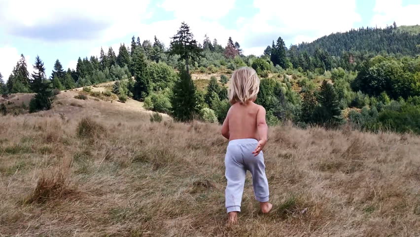 Little boy running on a hay field