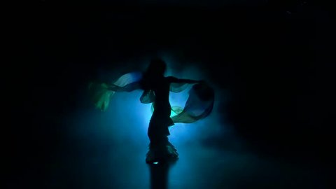 Beautiful exotic belly dancer woman continue dance, uses fans, on black, slow motion, silhouette, smoke