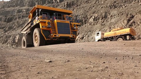 Heavy mining truck on the iron ore opencast mining quarry, big truck carries cargo in career, industrial exterior, ore mining quarry, sunny day, summer
