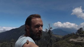 Happy man taking selfie photo, video during trekking, Indonesia, slow motion
